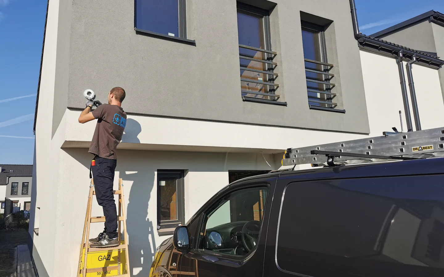 Technik PROelectrics montuje kamerę na elewacji domu jednorodzinnego