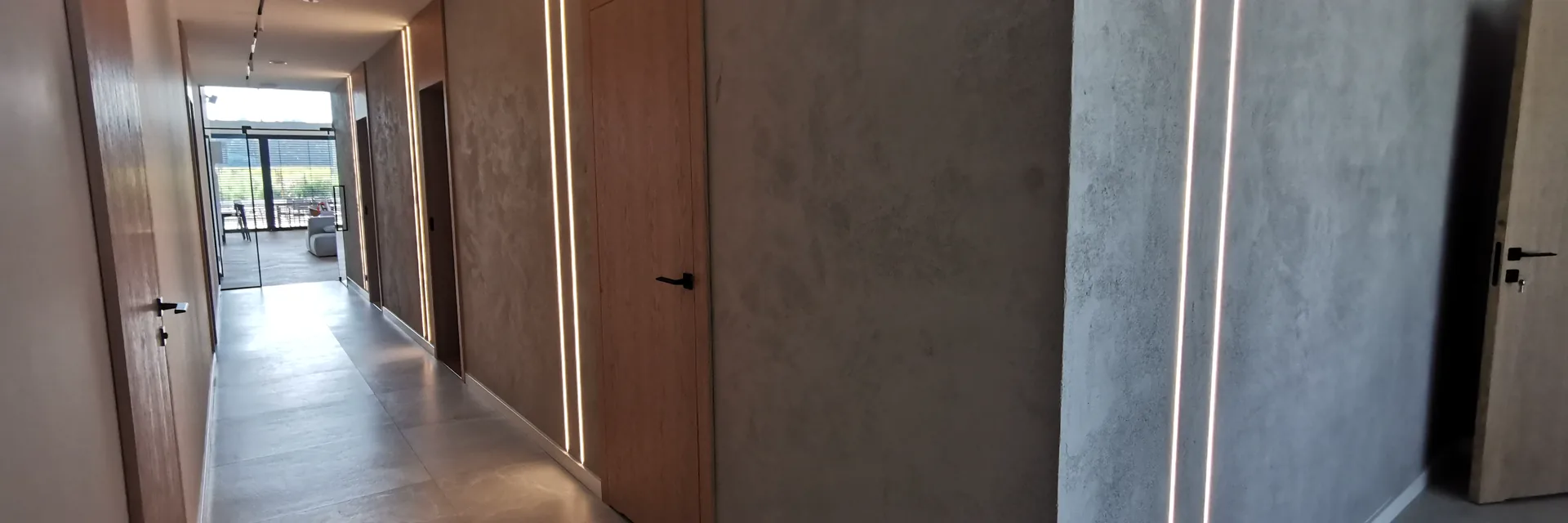 Korytarz z liniowym oświetleniem LED w mikrocemencie - realizacja smart home PROelectrics na Śląsku