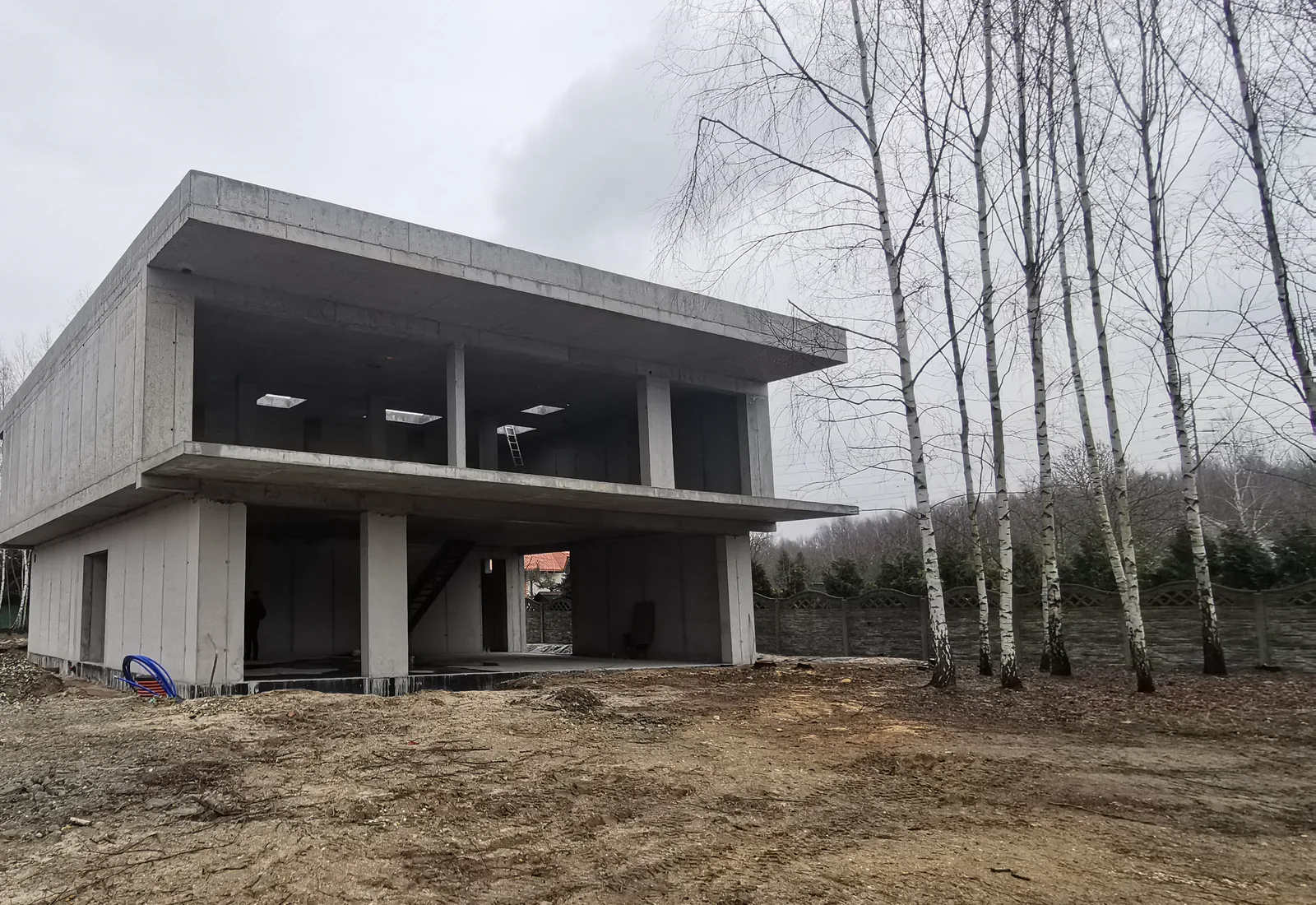 Nowy dom w stanie surowym - żelbetowy szkielet z dużymi przeszkleniami, etap na okablowanie Loxone Tree